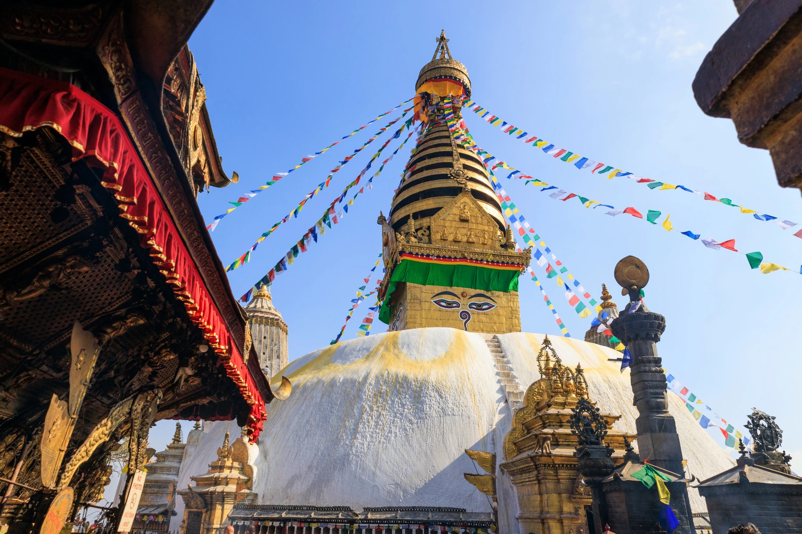 Swayambhunath Stupa dome with wisdom eyes, golden spire, and radiating prayer flags.
