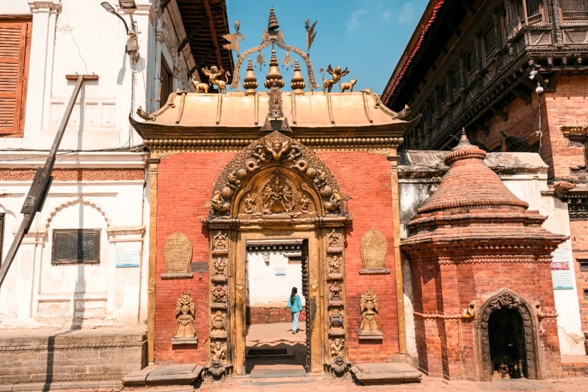 Golden Gate, Bhaktapur, Nepal, featuring intricate gilded carvings, red-brick walls, and traditional Newari shrines.