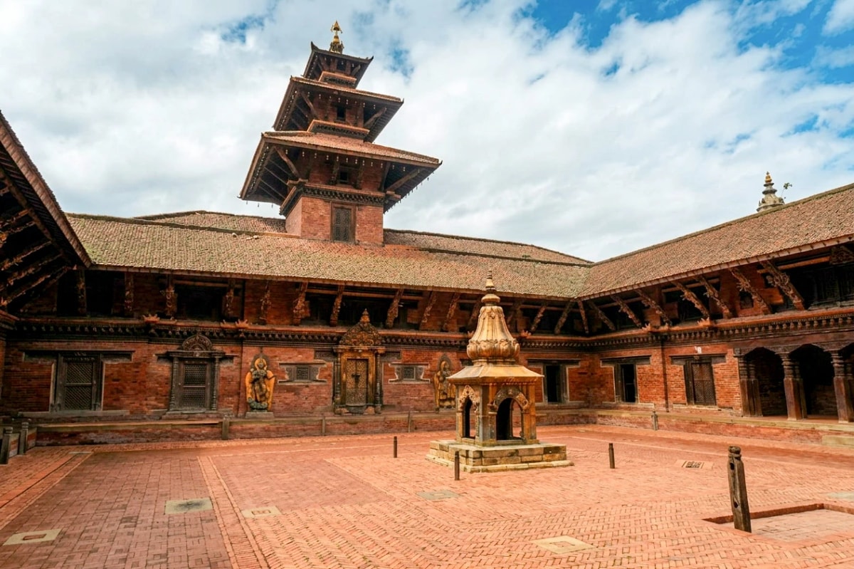 Mul Chowk courtyard at Patan Durbar Square, Nepal, featuring a traditional pagoda roof, brick architecture, and stone shrine.
