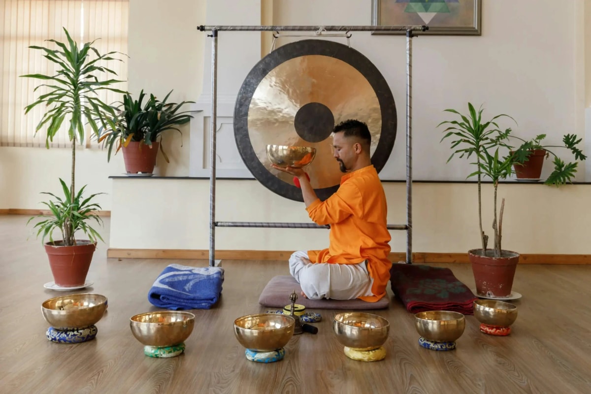 A practitioner plays a Tibetan singing bowl during a traditional sound therapy session.