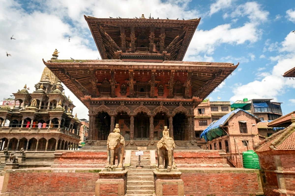 Vishwanath Temple in Patan Durbar Square, Nepal, featuring a two-tiered pagoda roof and stone elephant statues.