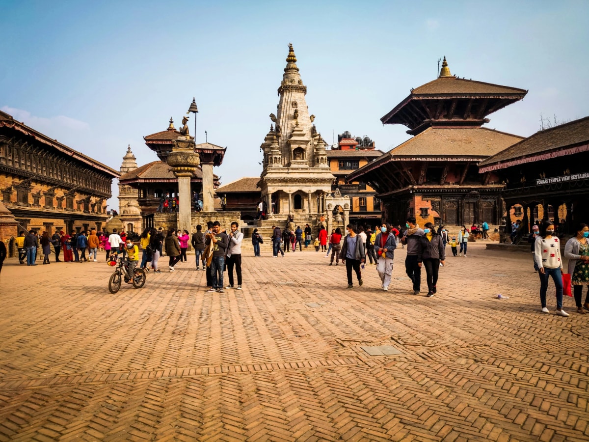 Bhaktapur Durbar Square, featuring five-tiered pagoda temple, brick steps, stone guardians, and Newari architecture.