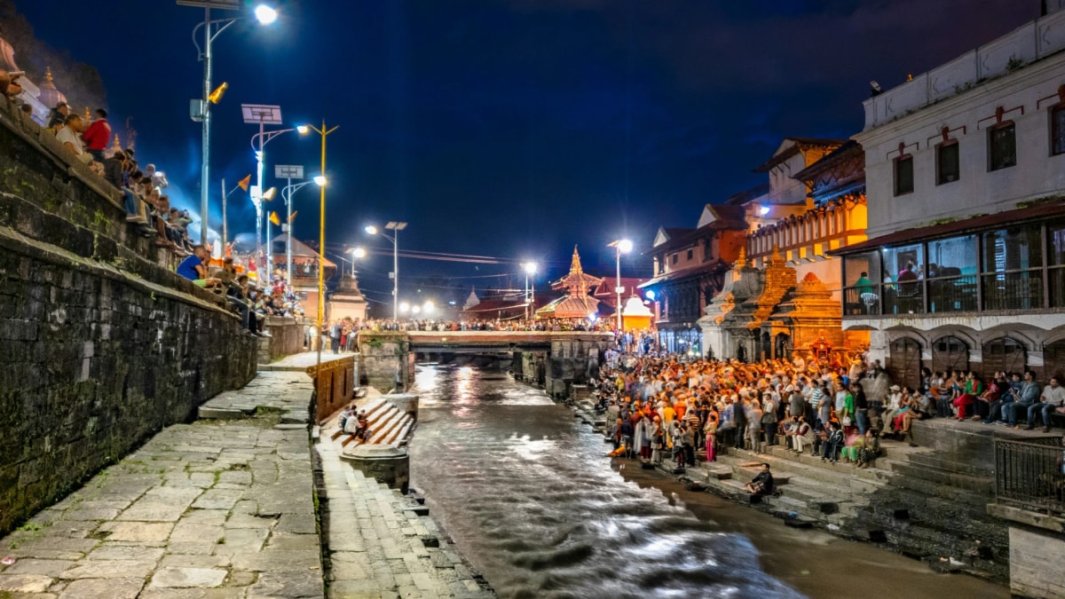 Evening crowds gather beside the Bagmati River for rituals near Pashupatinath Temple, Nepal.