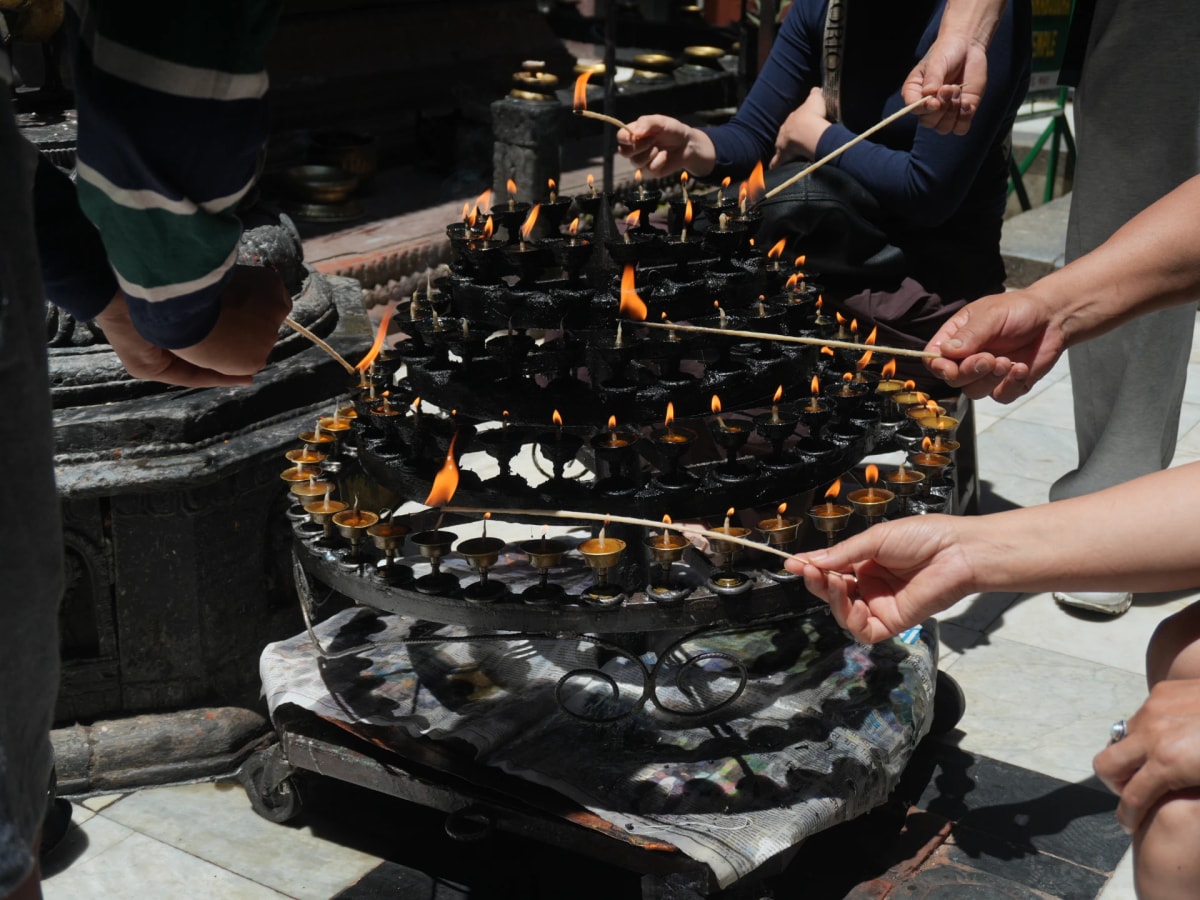 Devotees light butter lamp at Mahabouddha